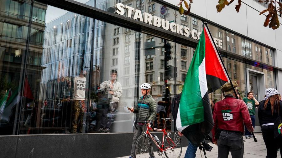 People watch from inside a Starbucks as demonstrators march in support of Palestinians in Gaza, amid the ongoing conflict between Israel and Hamas, in Washington, U.S., November 4, 2023. REUTERS/Elizabeth Frantz