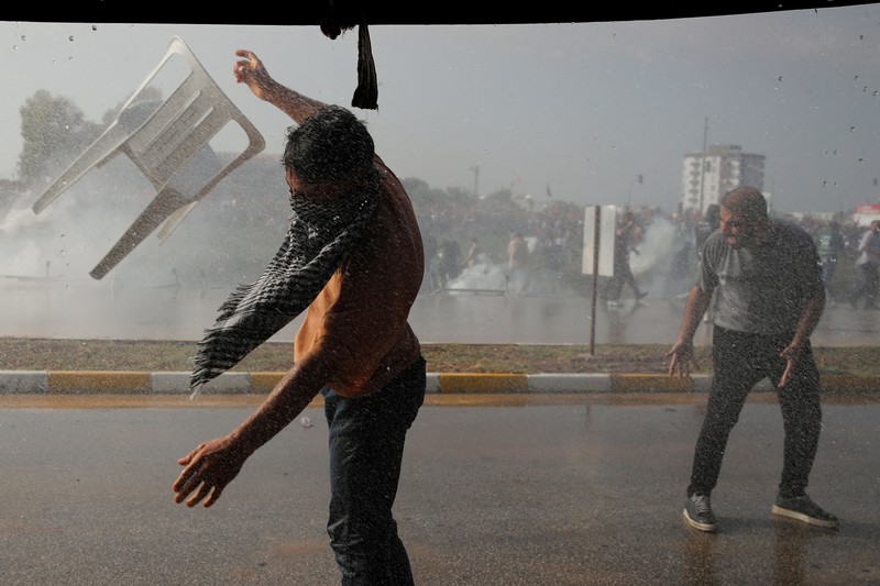 Orang-orang berkumpul dalam protes untuk menunjukkan solidaritas mereka terhadap warga Palestina di luar pangkalan udara militer Incirlik AS di Adana, Turki selatan, Minggu, 5 November 2023. (AP Photo/Mehmet Sancakzade)