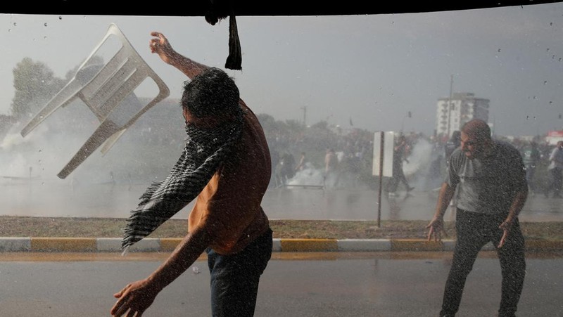 Orang-orang berkumpul dalam protes untuk menunjukkan solidaritas mereka terhadap warga Palestina di luar pangkalan udara militer Incirlik AS di Adana, Turki selatan, Minggu, 5 November 2023. (AP Photo/Mehmet Sancakzade)