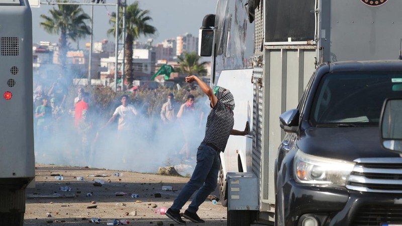 Orang-orang berkumpul dalam protes untuk menunjukkan solidaritas mereka terhadap warga Palestina di luar pangkalan udara militer Incirlik AS di Adana, Turki selatan, Minggu, 5 November 2023. (AP Photo/Mehmet Sancakzade)