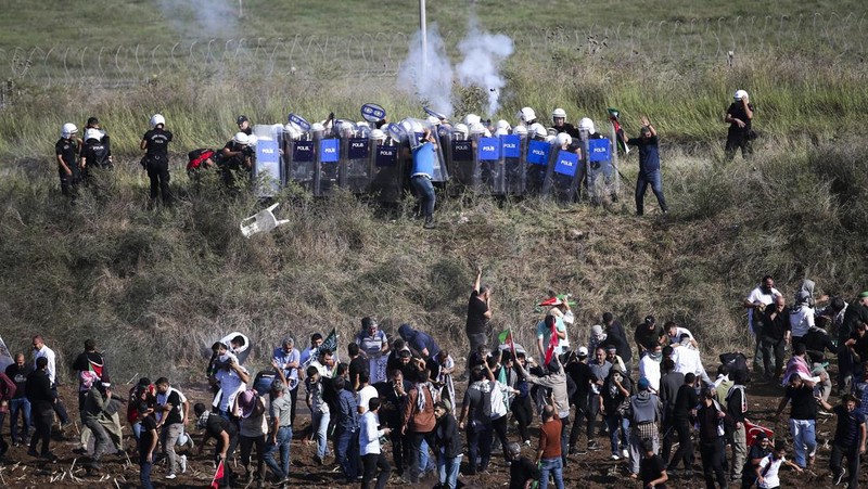 Orang-orang berkumpul dalam protes untuk menunjukkan solidaritas mereka terhadap warga Palestina di luar pangkalan udara militer Incirlik AS di Adana, Turki selatan, Minggu, 5 November 2023. (AP Photo/Mehmet Sancakzade)