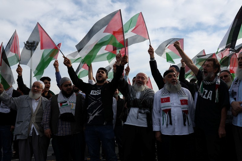 Orang-orang berkumpul dalam protes untuk menunjukkan solidaritas mereka terhadap warga Palestina di luar pangkalan udara militer Incirlik AS di Adana, Turki selatan, Minggu, 5 November 2023. (AP Photo/Mehmet Sancakzade)