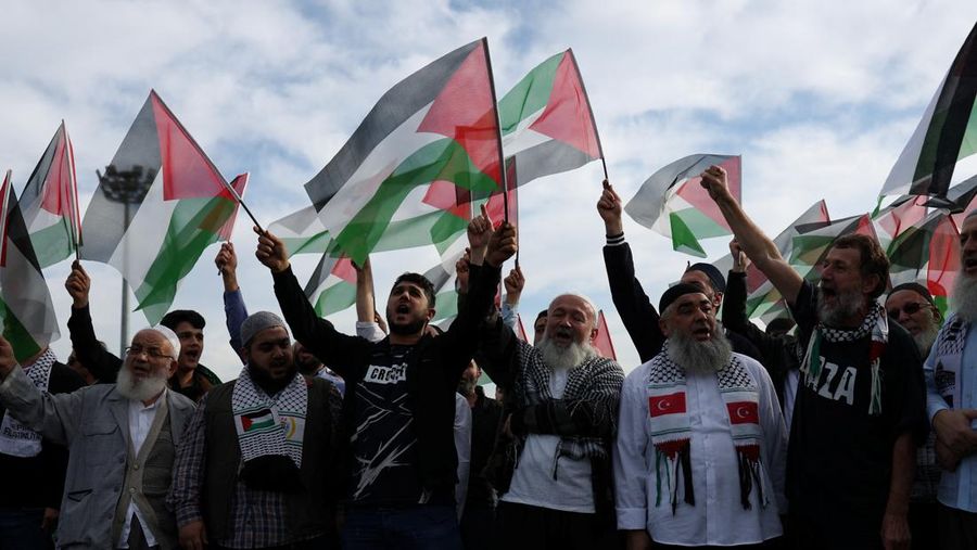 Orang-orang berkumpul dalam protes untuk menunjukkan solidaritas mereka terhadap warga Palestina di luar pangkalan udara militer Incirlik AS di Adana, Turki selatan, Minggu, 5 November 2023. (AP Photo/Mehmet Sancakzade)