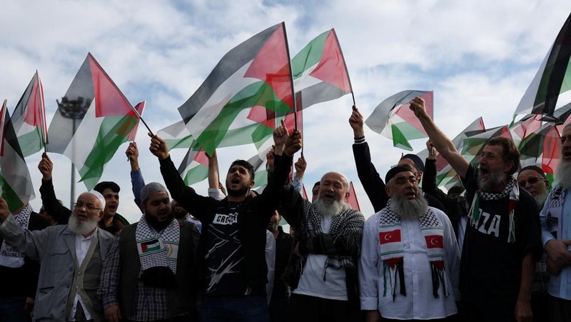 Orang-orang berkumpul dalam protes untuk menunjukkan solidaritas mereka terhadap warga Palestina di luar pangkalan udara militer Incirlik AS di Adana, Turki selatan, Minggu, 5 November 2023. (AP Photo/Mehmet Sancakzade)