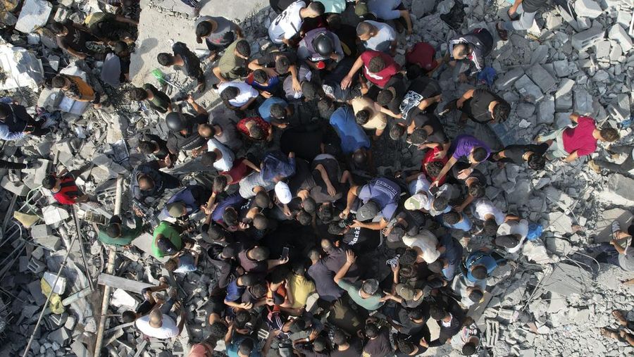 Warga Palestina mencari korban selamat dari pemboman Israel di kamp pengungsi Maghazi di Jalur Gaza pada Minggu, 5 November 2023. (AP Photo/Hatem Moussa)