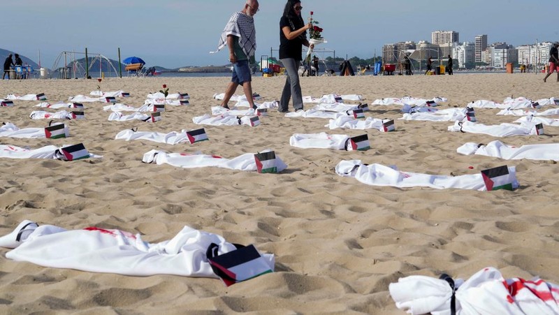 Seratus dua puluh kain kafan yang dipasang oleh anggota LSM Rio da Paz, di pantai untuk menghormati anak-anak Palestina yang terbunuh dalam konflik Israel-Hamas Gaza yang sedang berlangsung, selama demonstrasi pro-Palestina di Rio de Janeiro, Brasil, 3 November 2023. (REUTERS/Ian Cheibub)