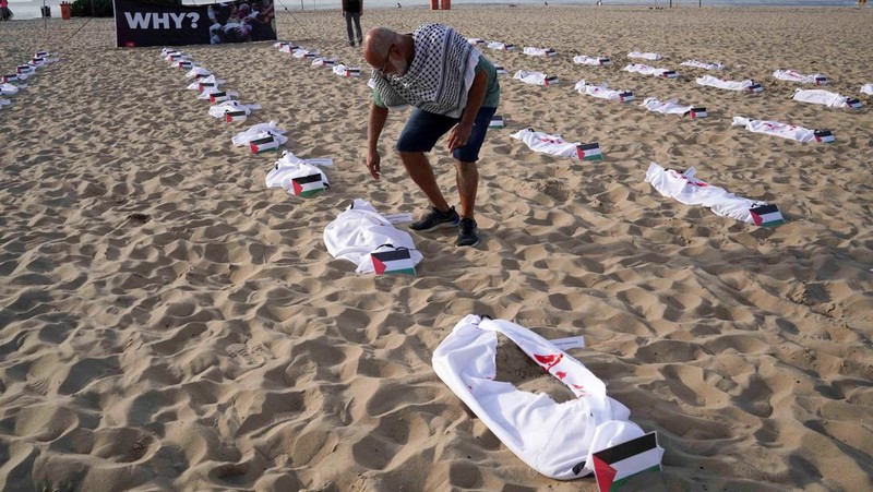 Seratus dua puluh kain kafan yang dipasang oleh anggota LSM Rio da Paz, di pantai untuk menghormati anak-anak Palestina yang terbunuh dalam konflik Israel-Hamas Gaza yang sedang berlangsung, selama demonstrasi pro-Palestina di Rio de Janeiro, Brasil, 3 November 2023. (REUTERS/Ian Cheibub)