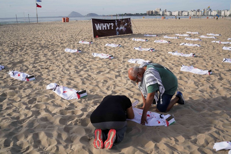 Seratus dua puluh kain kafan yang dipasang oleh anggota LSM Rio da Paz, di pantai untuk menghormati anak-anak Palestina yang terbunuh dalam konflik Israel-Hamas Gaza yang sedang berlangsung, selama demonstrasi pro-Palestina di Rio de Janeiro, Brasil, 3 November 2023. Seratus dua puluh kain kafan yang dipasang oleh anggota LSM Rio da Paz, di pantai untuk menghormati anak-anak Palestina yang terbunuh dalam konflik Israel-Hamas Gaza yang sedang berlangsung, selama demonstrasi pro-Palestina di Rio de Janeiro, Brasil, 3 November 2023. (REUTERS/Ian Cheibub)