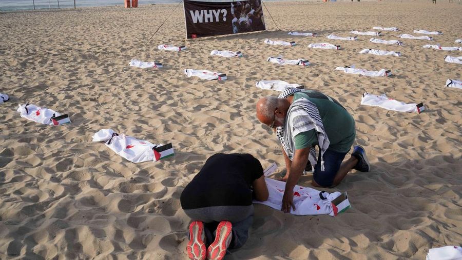 Seratus dua puluh kain kafan yang dipasang oleh anggota LSM Rio da Paz, di pantai untuk menghormati anak-anak Palestina yang terbunuh dalam konflik Israel-Hamas Gaza yang sedang berlangsung, selama demonstrasi pro-Palestina di Rio de Janeiro, Brasil, 3 November 2023. (REUTERS/Ian Cheibub)