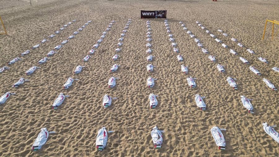 Seratus dua puluh kain kafan yang dipasang oleh anggota LSM Rio da Paz, di pantai untuk menghormati anak-anak Palestina yang terbunuh dalam konflik Israel-Hamas Gaza yang sedang berlangsung, selama demonstrasi pro-Palestina di Rio de Janeiro, Brasil, 3 November 2023. (REUTERS/Ian Cheibub)
