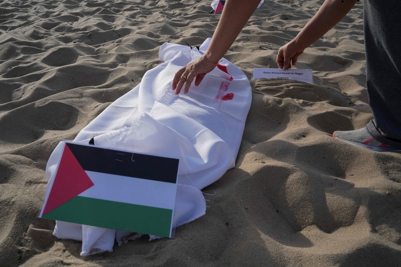 Seratus dua puluh kain kafan yang dipasang oleh anggota LSM Rio da Paz, di pantai untuk menghormati anak-anak Palestina yang terbunuh dalam konflik Israel-Hamas Gaza yang sedang berlangsung, selama demonstrasi pro-Palestina di Rio de Janeiro, Brasil, 3 November 2023. Seratus dua puluh kain kafan yang dipasang oleh anggota LSM Rio da Paz, di pantai untuk menghormati anak-anak Palestina yang terbunuh dalam konflik Israel-Hamas Gaza yang sedang berlangsung, selama demonstrasi pro-Palestina di Rio de Janeiro, Brasil, 3 November 2023. (REUTERS/Ian Cheibub)