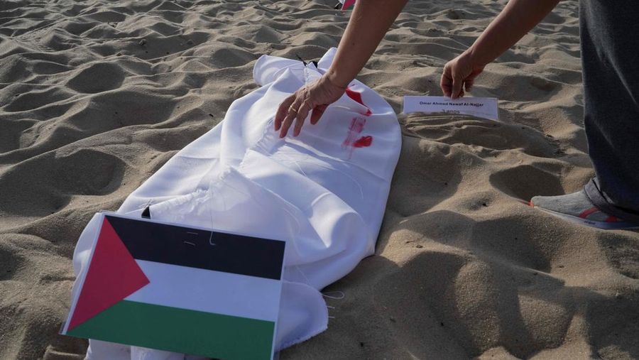 Seratus dua puluh kain kafan yang dipasang oleh anggota LSM Rio da Paz, di pantai untuk menghormati anak-anak Palestina yang terbunuh dalam konflik Israel-Hamas Gaza yang sedang berlangsung, selama demonstrasi pro-Palestina di Rio de Janeiro, Brasil, 3 November 2023. (REUTERS/Ian Cheibub)