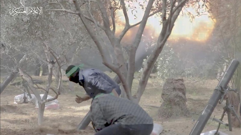Gambar diam yang diambil dari video yang dirilis oleh Hamas menunjukkan apa yang dikatakannya sebagai pejuangnya menembakkan mortir ke pasukan Israel selama serangan darat Israel, di lokasi yang disebutkan sebagai Gaza, yang diperoleh Reuters pada 7 November 2023. (Hamas Military Wing/Handout via REUTERS)