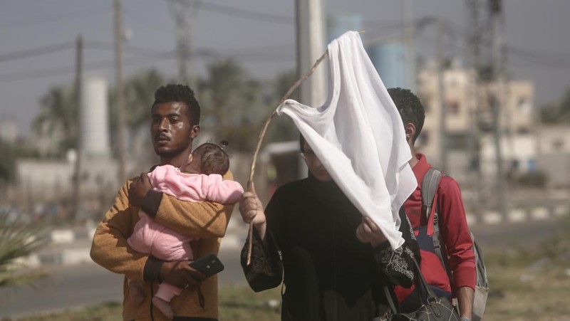 Sejumlah warga Palestina berbondong-bondong jalan sambil mengibarkan bendera putih saat mereka mengikuti perintah Israel untuk evakuasi dari Gaza utara ke selatan. (AP Photo/Abed Khaled)