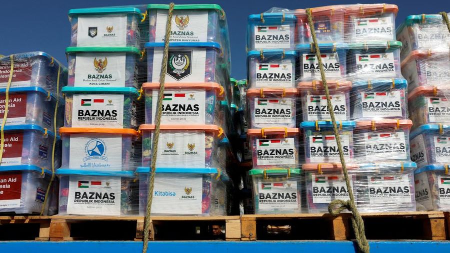 Seorang anggota unit K-9 bea cukai Israel dan seekor anjing memeriksa sebuah truk dengan pasokan kemanusiaan menuju Gaza, di tengah konflik yang sedang berlangsung antara Israel dan kelompok Islam Palestina Hamas, di penyeberangan perbatasan Nitzana di Israel 9 November 2023. (REUTERS/Evelyn Hockstein)