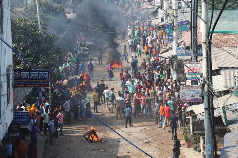 Pekerja garmen berkumpul di sepanjang jalan selama protes di Gazipur pada tanggal 9 November 2023, setelah otoritas Dewan Upah Minimum mengumumkan upah minimum sebesar 12.500 taka ($113) untuk pekerja garmen. Pekerja garmen berkumpul di sepanjang jalan selama protes di Gazipur pada tanggal 9 November 2023, setelah otoritas Dewan Upah Minimum mengumumkan upah minimum sebesar 12.500 taka ($113) untuk pekerja garmen. Polisi menembakkan peluru karet dan gas air mata ke arah pengunjuk rasa pada tanggal 9 November ketika ribuan pekerja garmen Bangladesh menolak kenaikan upah yang