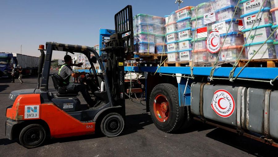 Seorang pekerja menggunakan forklift untuk memuat kotak berisi pasokan kemanusiaan menuju Gaza ke dalam truk, di tengah konflik yang sedang berlangsung antara Israel dan kelompok Islam Palestina Hamas, di penyeberangan perbatasan Nitzana di Israel 9 November 2023. (REUTERS/Evelyn Hockstein)