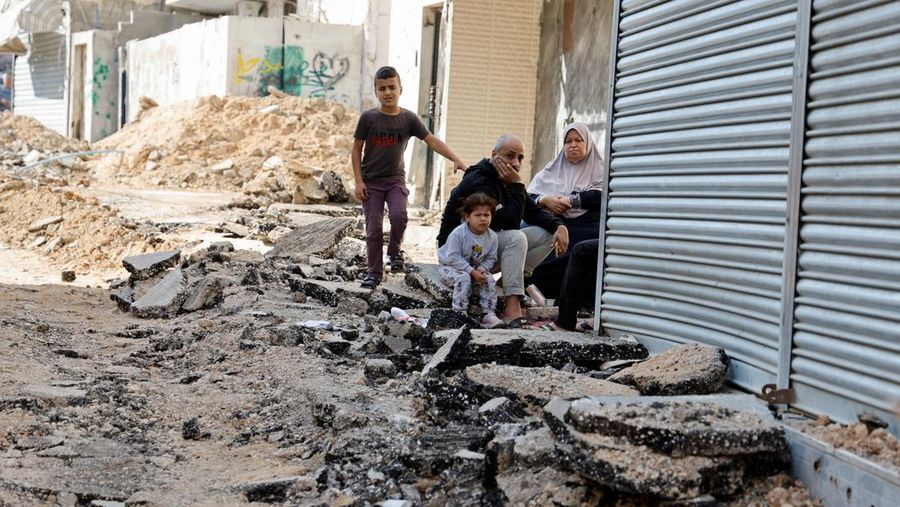 Warga Palestina melihat jalan yang rusak setelah serangan Israel, di kamp pengungsi Jenin di Tepi Barat. (REUTERS/Raneen Sawafta)