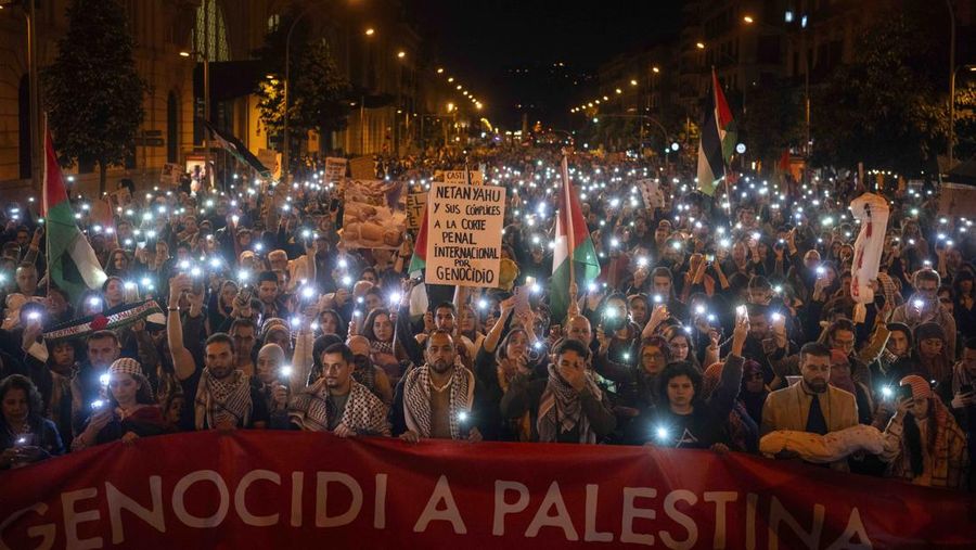 Demonstrators use the flashlights on their mobile phones as they protest against Israeli attacks on Gaza, in Barcelona, Spain, Saturday, Nov. 11, 2023. (AP Photo/Emilio Morenatti)