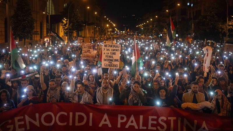 Demonstrators use the flashlights on their mobile phones as they protest against Israeli attacks on Gaza, in Barcelona, Spain, Saturday, Nov. 11, 2023. (AP Photo/Emilio Morenatti)