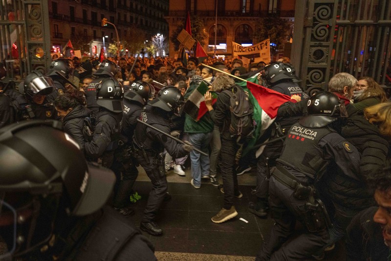 Spain Israel Palestinians Demonstrators use the flashlights on their mobile phones as they protest against Israeli attacks on Gaza, in Barcelona, Spain, Saturday, Nov. 11, 2023. (AP Photo/Emilio Morenatti)