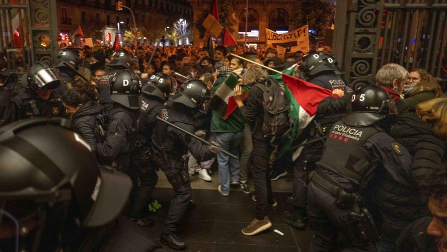 Demonstrators use the flashlights on their mobile phones as they protest against Israeli attacks on Gaza, in Barcelona, Spain, Saturday, Nov. 11, 2023. (AP Photo/Emilio Morenatti)