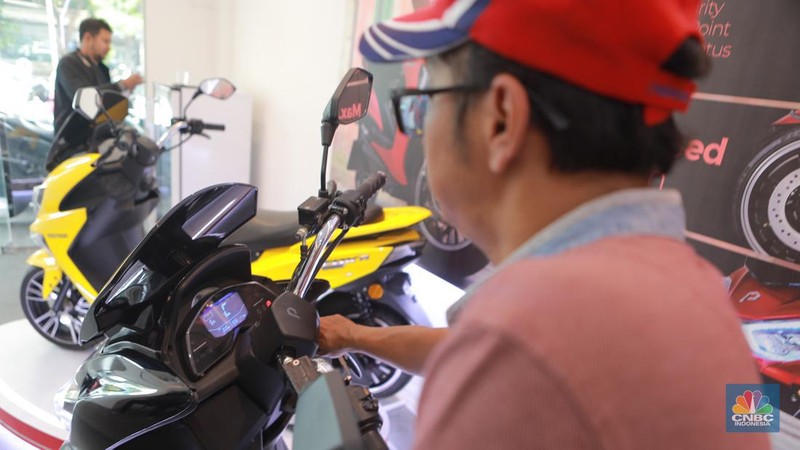 Calon pembeli melihat motor listrik dinsalah satu dealer motor di Kawasan Arteri, Jakarta Selatan, Senin (13/11/2023). (CNBC Indonesia/Muhammad Sabki)