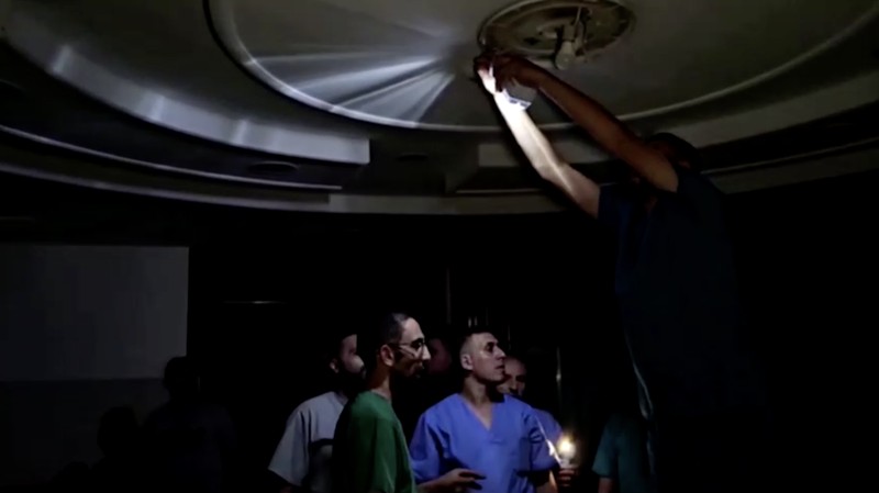 Tim medis di RS Indonesia Gaza menggunakan senter di tengah pemadaman listrik. (Tangkapan Layar Video Reuters)