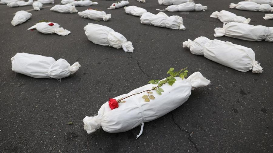 Kafan simbolis mayat anak-anak Gaza terlihat saat memberi isyarat di sebuah jalan di Teheran, Iran 13 November 2023. (Majid Asgaripour/WANA (West Asia News Agency) via REUTERS)