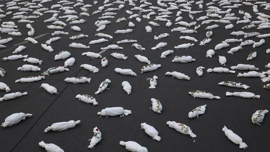 Kafan simbolis mayat anak-anak Gaza terlihat saat memberi isyarat di sebuah jalan di Teheran, Iran 13 November 2023. (Majid Asgaripour/WANA (West Asia News Agency) via REUTERS)