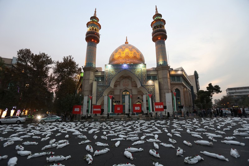 Kafan simbolis mayat anak-anak Gaza terlihat saat memberi isyarat di sebuah jalan di Teheran, Iran 13 November 2023. Kafan simbolis mayat anak-anak Gaza terlihat saat memberi isyarat di sebuah jalan di Teheran, Iran 13 November 2023. (Majid Asgaripour/WANA (West Asia News Agency) via REUTERS)