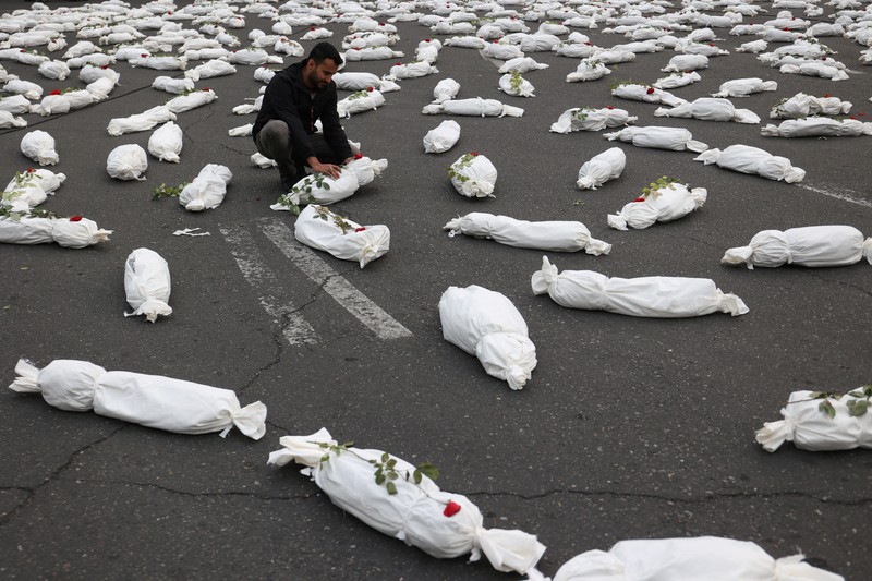 Kafan simbolis mayat anak-anak Gaza terlihat saat memberi isyarat di sebuah jalan di Teheran, Iran 13 November 2023. (Majid Asgaripour/WANA (West Asia News Agency) via REUTERS)