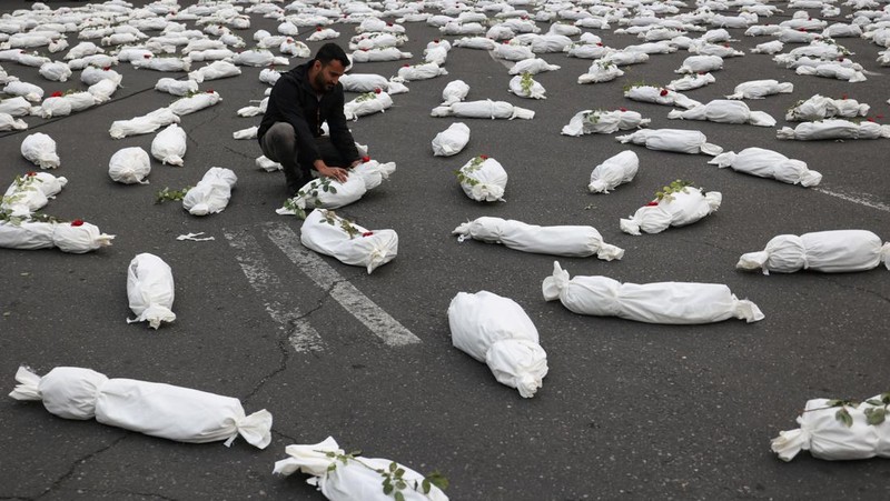Kafan simbolis mayat anak-anak Gaza terlihat saat memberi isyarat di sebuah jalan di Teheran, Iran 13 November 2023. (Majid Asgaripour/WANA (West Asia News Agency) via REUTERS)