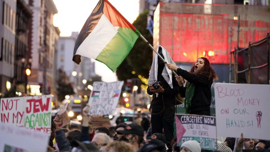 Para pengunjuk rasa berbaris dan mengibarkan bendera menentang perang Israel-Hamas bersamaan dengan KTT APEC yang berlangsung Selasa, 14 November 2023, di San Francisco. Para pengunjuk rasa berbaris dan mengibarkan bendera menentang perang Israel-Hamas bersamaan dengan KTT APEC yang berlangsung Selasa, 14 November 2023, di San Francisco. (AP Photo/Godofredo A. Vásquez)