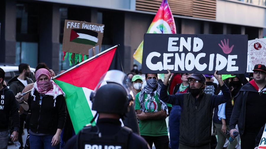 Seseorang memegang bendera Palestina pada protes di dekat Moscone Center, selama KTT APEC (Asia-Pacific Economic Cooperation), di San Francisco, California, AS, 12 November 2023. (REUTERS/Carlos Barria)