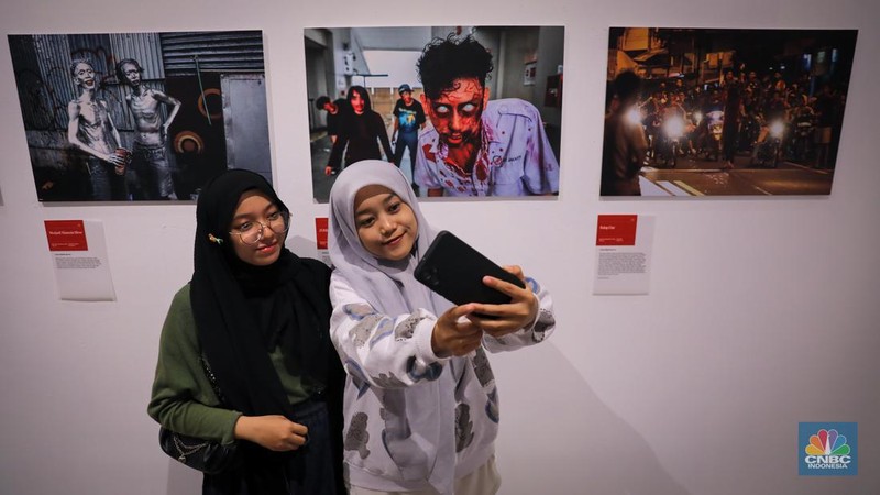 Pengunjung melihat pameran fotografi tahunan bertajuk Rekam Jakarta di Galeri Emiria Soenassa Taman Ismail Marzuki, Jakarta, Jumat (17/11/2023). (CNBC Indonesia/Faisal Rahman)