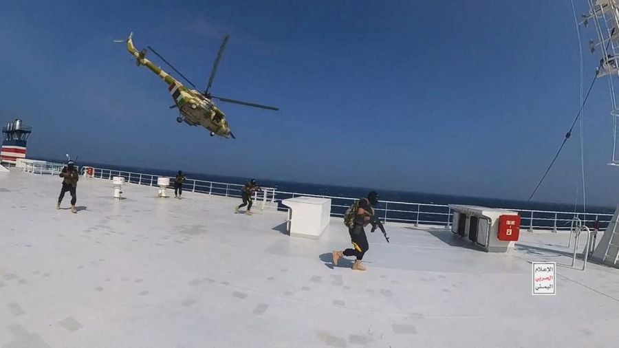 Helikopter militer Houthi melayang di atas kapal kargo Galaxy Leader saat pejuang Houthi berjalan di dek kapal di Laut Merah dalam foto yang dirilis 20 November 2023. (Houthi Military Media/Handout via REUTERS)