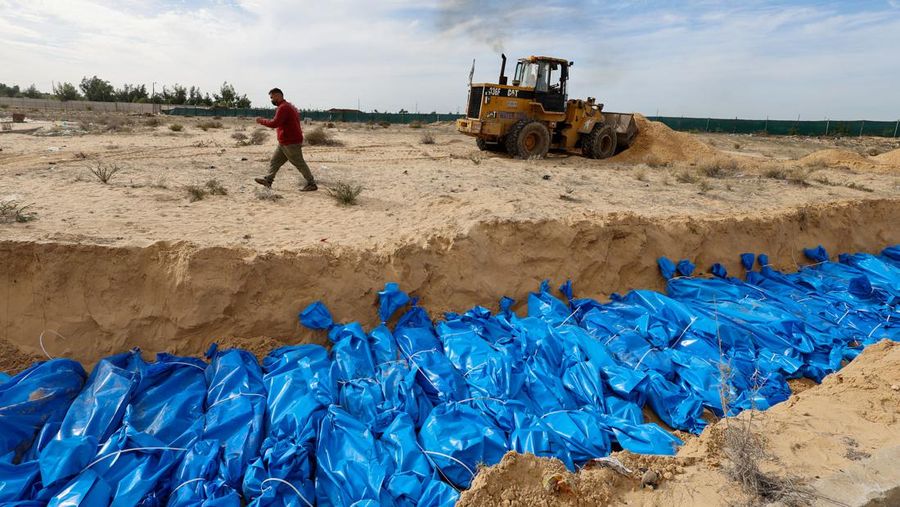 The bodies of Palestinians killed in Israeli strikes and fire are buried in a mass grave, after they were transported from Al Shifa hospital in Gaza City for burial, in Khan Younis in the southern Gaza Strip November 22, 2023. REUTERS/Mohammed Salem