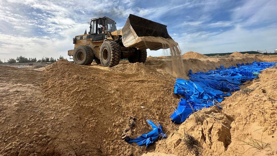 The bodies of Palestinians killed in Israeli strikes and fire are buried in a mass grave, after they were transported from Al Shifa hospital in Gaza City for burial, in Khan Younis in the southern Gaza Strip November 22, 2023. REUTERS/Mohammed Salem