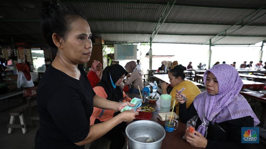 Para buruh pabrik garmen berbelanja makan siang dari pedagang kaki lima di luar pabrik di kawasan Jakarta, Kamis (23/11/2023). (²©²ÊÍøÕ¾/Tri Susilo)