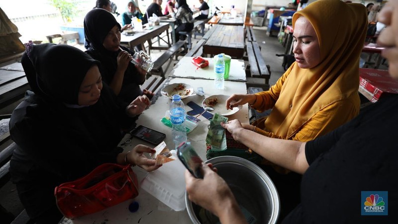Para buruh pabrik garmen berbelanja makan siang dari pedagang kaki lima di luar pabrik di kawasan Jakarta, Kamis (23/11/2023). (CNBC Indonesia/Tri Susilo)