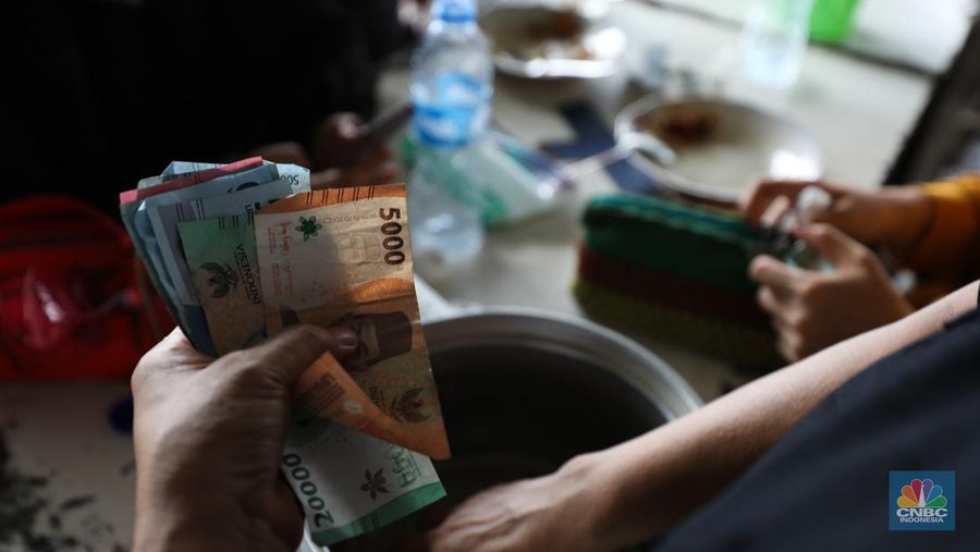 Para buruh pabrik garmen berbelanja makan siang dari pedagang kaki lima di luar pabrik di kawasan Jakarta, Kamis (23/11/2023). (վ/Tri Susilo)