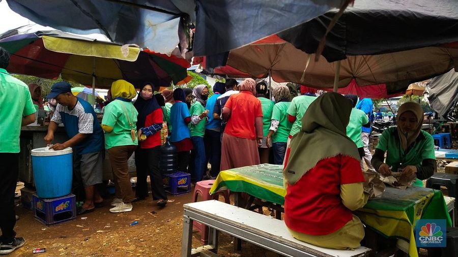 Para buruh pabrik garmen berbelanja makan siang dari pedagang kaki lima di luar pabrik di kawasan Jakarta, Kamis (23/11/2023). (վ/Tri Susilo)