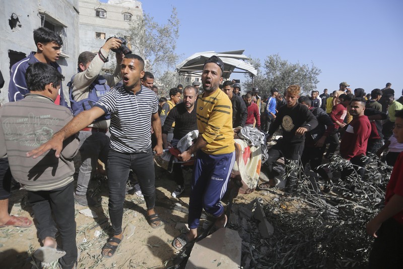 Warga Palestina mengevakuasi korban selamat pasca serangan Israel di Jalur Gaza di Rafah pada Sabtu, 23 November 2023. Warga Palestina mengevakuasi korban selamat pasca serangan Israel di Jalur Gaza di Rafah pada Sabtu, 23 November 2023. (AP Photo/Hatem Ali)