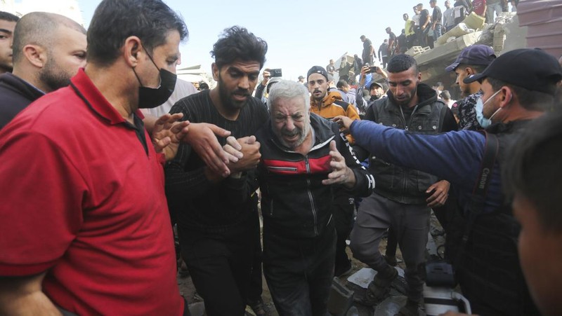 Warga Palestina mengevakuasi korban selamat pasca serangan Israel di Jalur Gaza di Rafah pada Sabtu, 23 November 2023. (AP Photo/Hatem Ali)