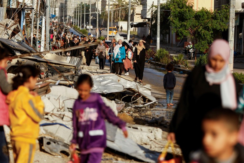 Pengungsi Palestina berjalan di jalan saat mereka kembali ke rumah mereka, selama gencatan senjata sementara antara Hamas dan Israel, di Khan Younis di selatan Jalur Gaza, 24 November 2023. Pengungsi Palestina berjalan di jalan saat mereka kembali ke rumah mereka, selama gencatan senjata sementara antara Hamas dan Israel, di Khan Younis di selatan Jalur Gaza, 24 November 2023. (REUTERS/Ibraheem Abu Mustafa)