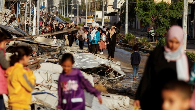 Pengungsi Palestina berjalan di jalan saat mereka kembali ke rumah mereka, selama gencatan senjata sementara antara Hamas dan Israel, di Khan Younis di selatan Jalur Gaza, 24 November 2023. (REUTERS/Ibraheem Abu Mustafa)