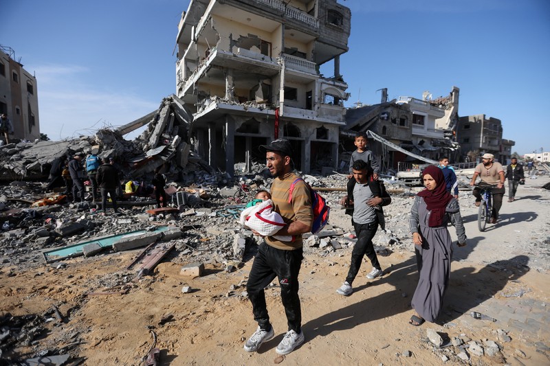 Pengungsi Palestina berjalan di jalan saat mereka kembali ke rumah mereka, selama gencatan senjata sementara antara Hamas dan Israel, di Khan Younis di selatan Jalur Gaza, 24 November 2023. Pengungsi Palestina berjalan di jalan saat mereka kembali ke rumah mereka, selama gencatan senjata sementara antara Hamas dan Israel, di Khan Younis di selatan Jalur Gaza, 24 November 2023. (REUTERS/Ibraheem Abu Mustafa)