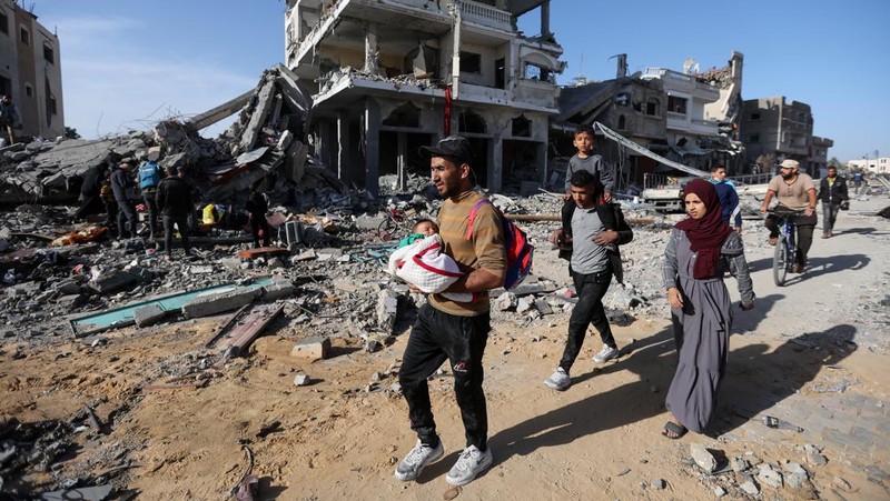 Pengungsi Palestina berjalan di jalan saat mereka kembali ke rumah mereka, selama gencatan senjata sementara antara Hamas dan Israel, di Khan Younis di selatan Jalur Gaza, 24 November 2023. (REUTERS/Ibraheem Abu Mustafa)