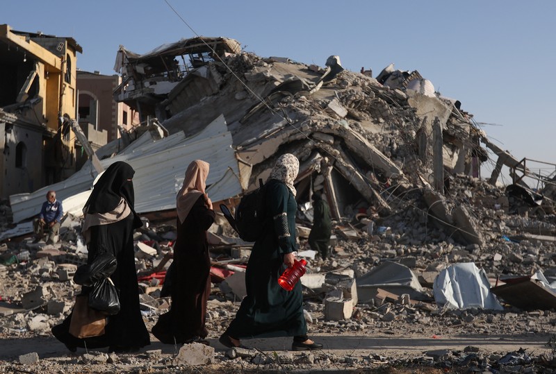 Pengungsi Palestina berjalan di jalan saat mereka kembali ke rumah mereka, selama gencatan senjata sementara antara Hamas dan Israel, di Khan Younis di selatan Jalur Gaza, 24 November 2023. Pengungsi Palestina berjalan di jalan saat mereka kembali ke rumah mereka, selama gencatan senjata sementara antara Hamas dan Israel, di Khan Younis di selatan Jalur Gaza, 24 November 2023. (REUTERS/Ibraheem Abu Mustafa)